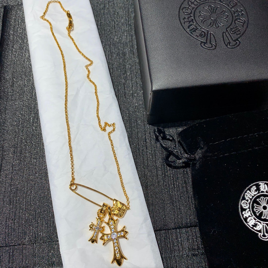 Gold cross pendant necklace with long chain and clasp detail