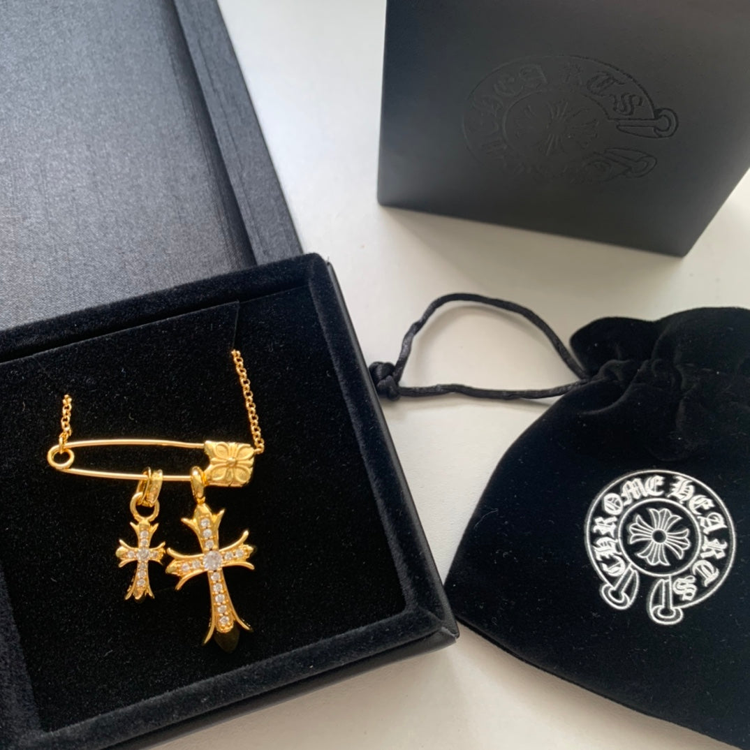Gold cross pendant necklace with chain, shown with gift box and pouch