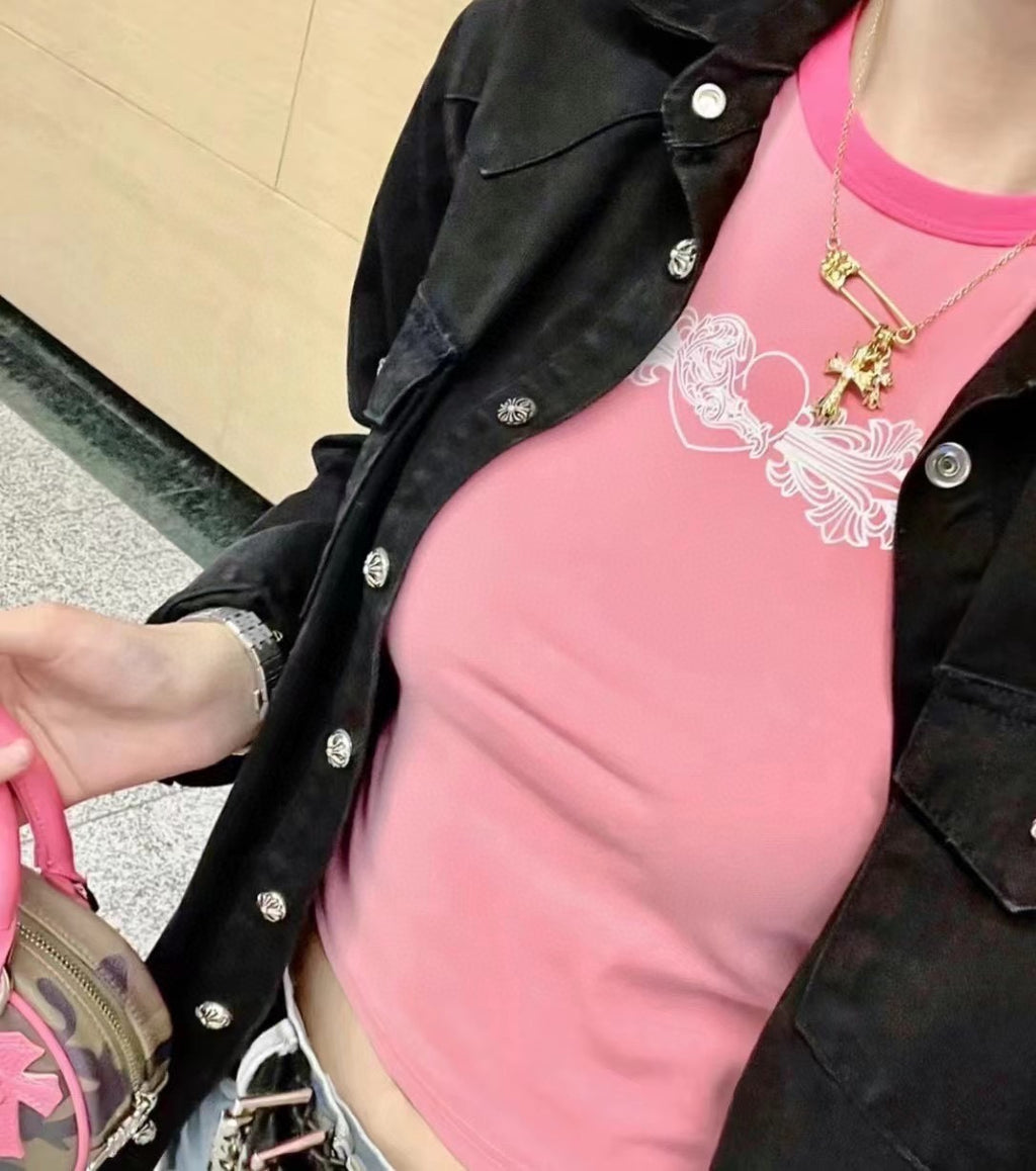 Gold cross pendant necklace on person with pink top