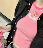 Gold cross pendant necklace on person with pink top