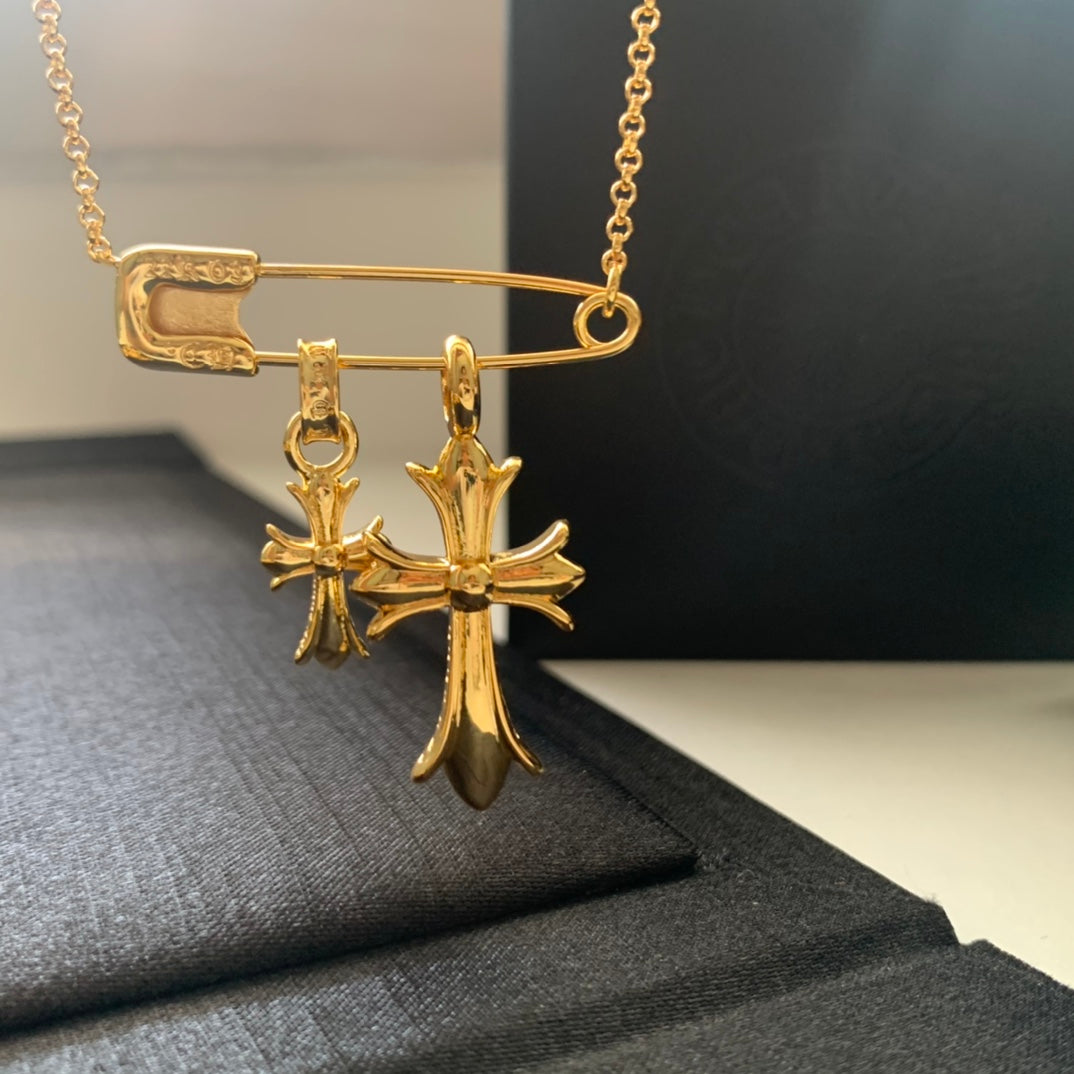 Gold chain necklace with two cross charms and bar clasp