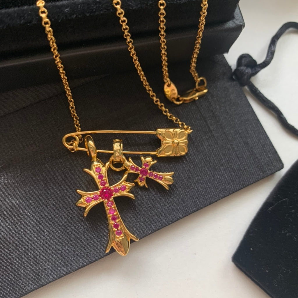 Gold cross pendant necklace with pink gemstone inlay and bar clasp