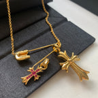 Gold chain necklace with cross pendants, pink gemstone accents, and clasp