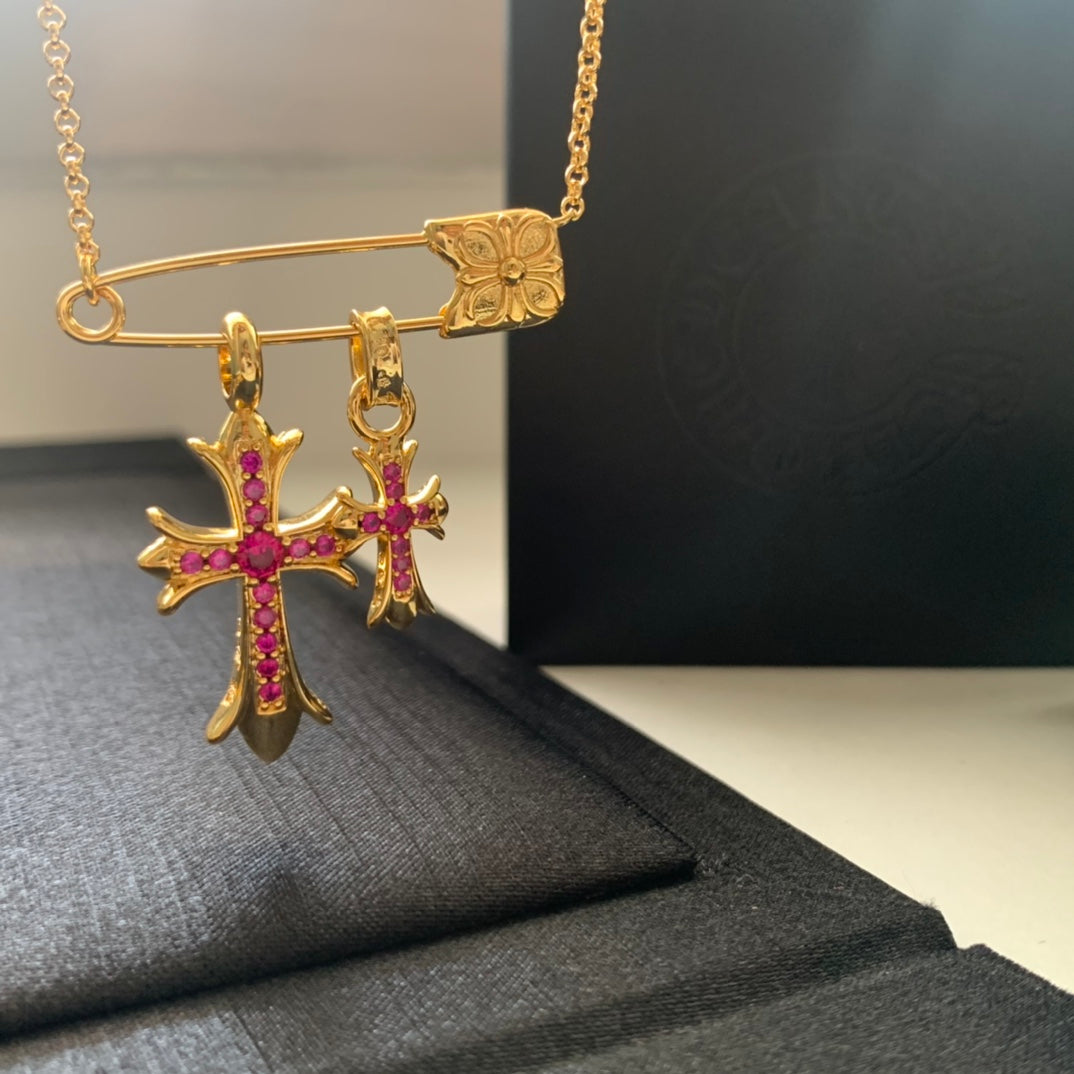 Gold chain necklace with pink cross pendant and dangling hoop charms