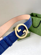Blue croc-embossed Gucci belt with gold-tone round GG buckle close-up