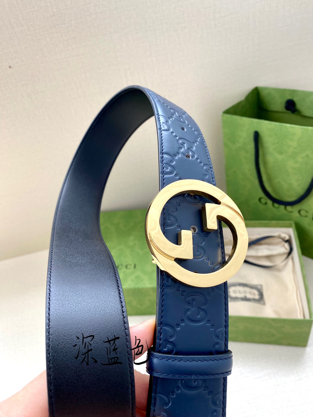 Gucci belt detail: dark blue strap with G buckle and gold center