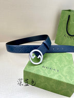Gucci belt front view: dark blue embossed strap with white-ring G buckle