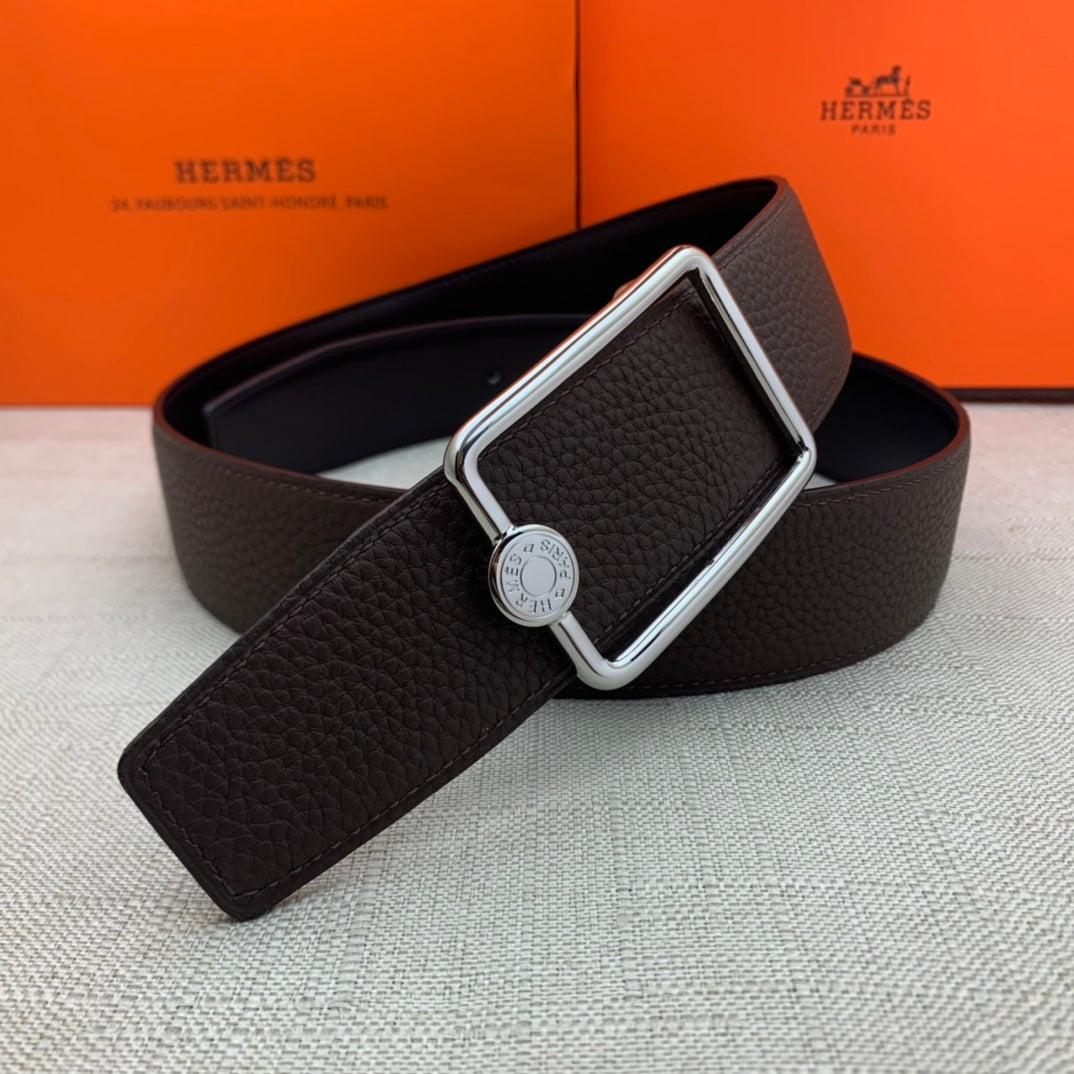 Leather belt with rectangular silver buckle and embossed strap, dark brown.
