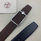 Embossed leather belt with rectangular silver buckle, dark brown strap.