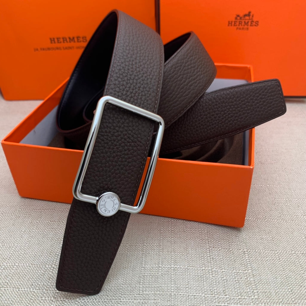 Leather belt with rectangular silver buckle and embossed strap, dark brown.
