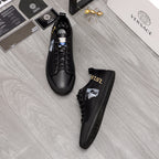 Versace black lace-up sneakers with gold side logo and white crest on one shoe