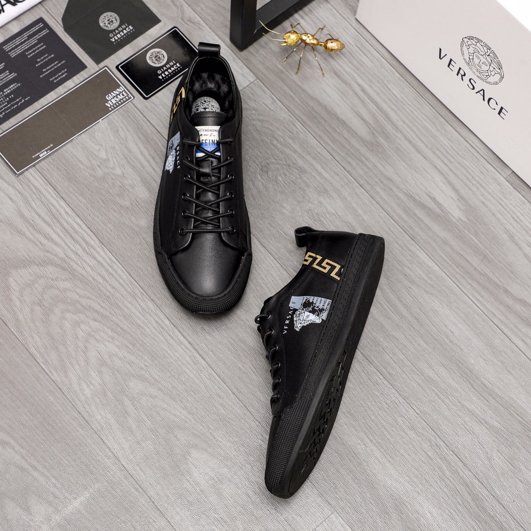 Versace black lace-up sneakers with gold side logo and white crest on one shoe