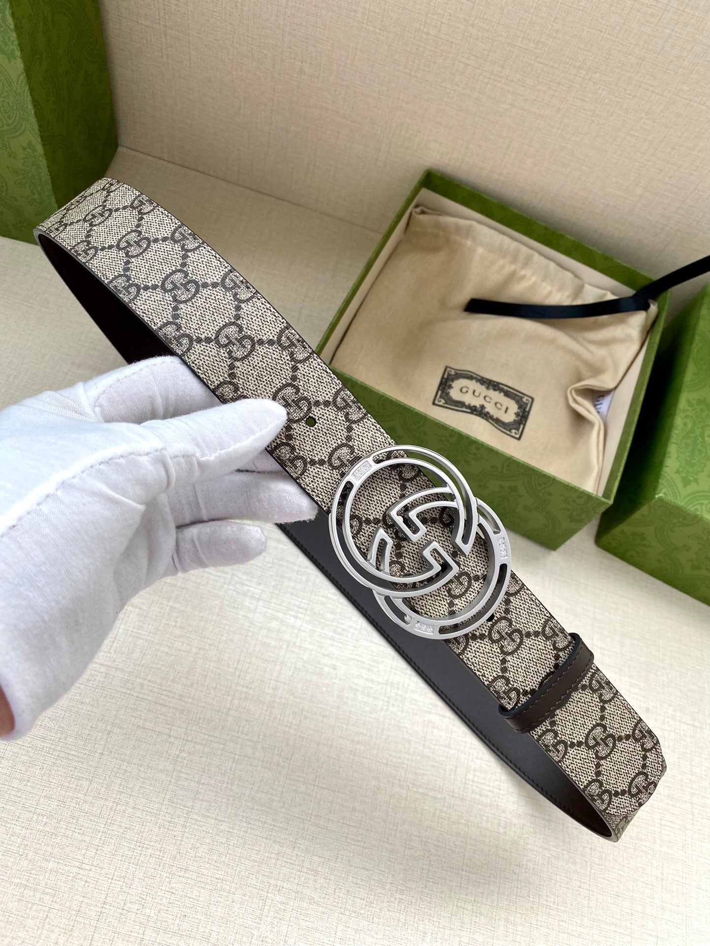 Gucci belt angled view: GG canvas strap with silver-tone interlocking G buckle