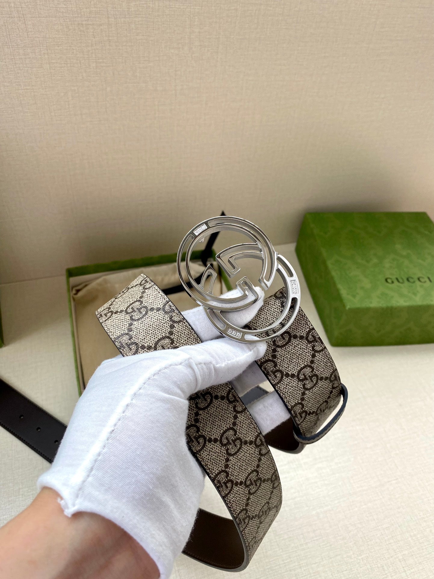 Gucci belt buckle detail on GG canvas with dark leather strap and silver-tone hardware