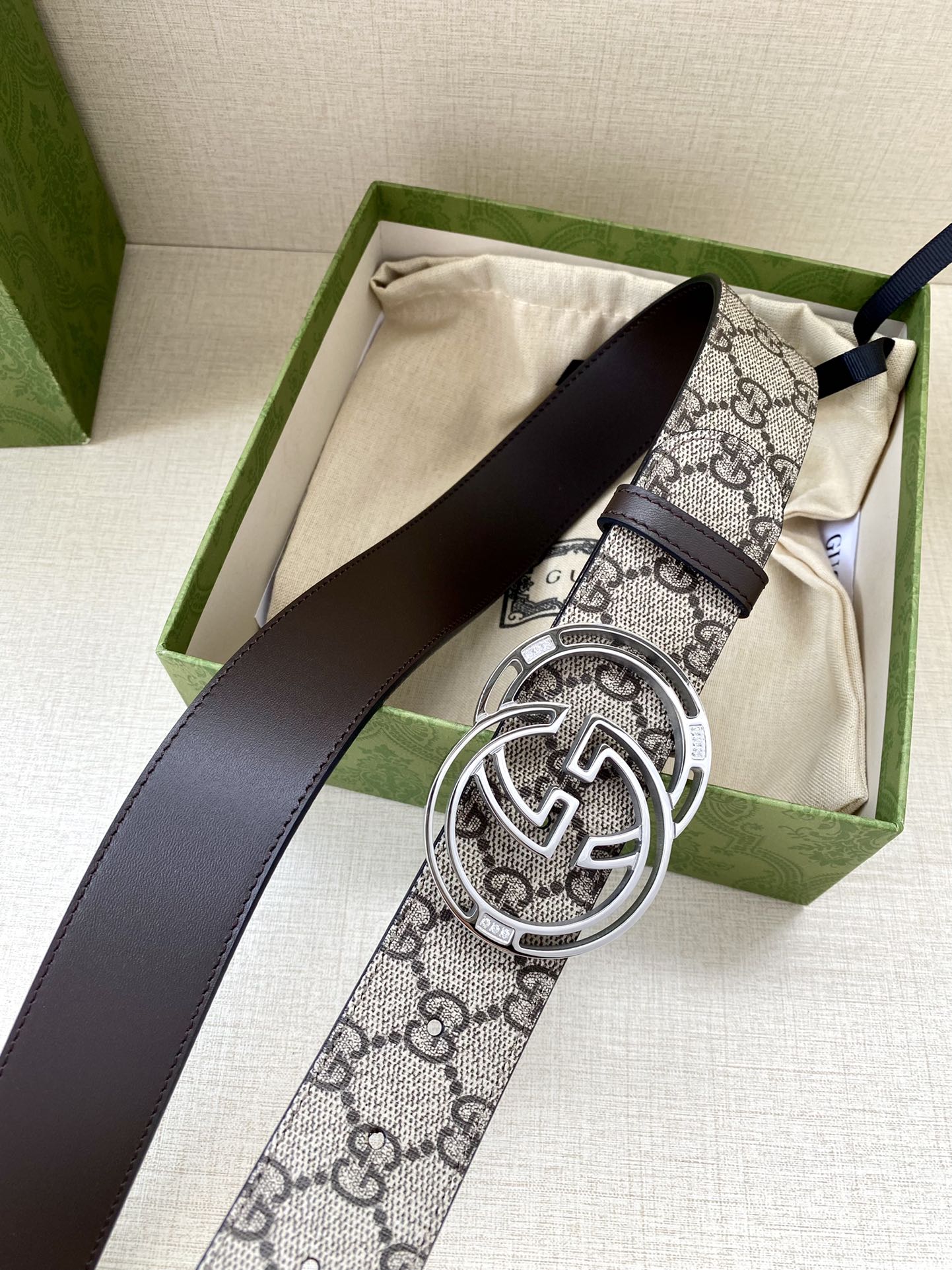 Gucci belt with GG canvas strap, dark leather strap, and silver-tone double G buckle