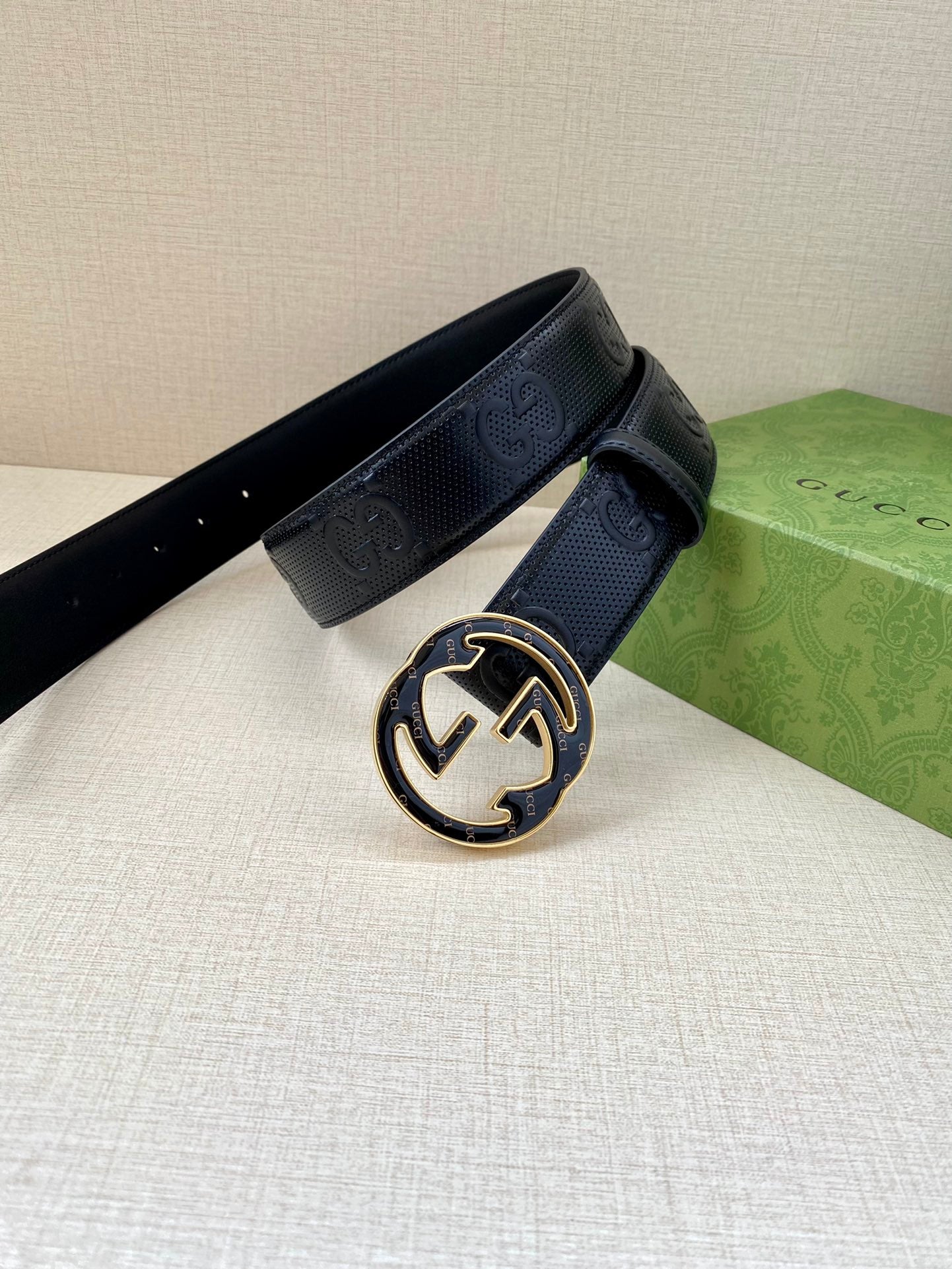 Gucci dark navy leather belt with oval GG buckle and textured belt strap