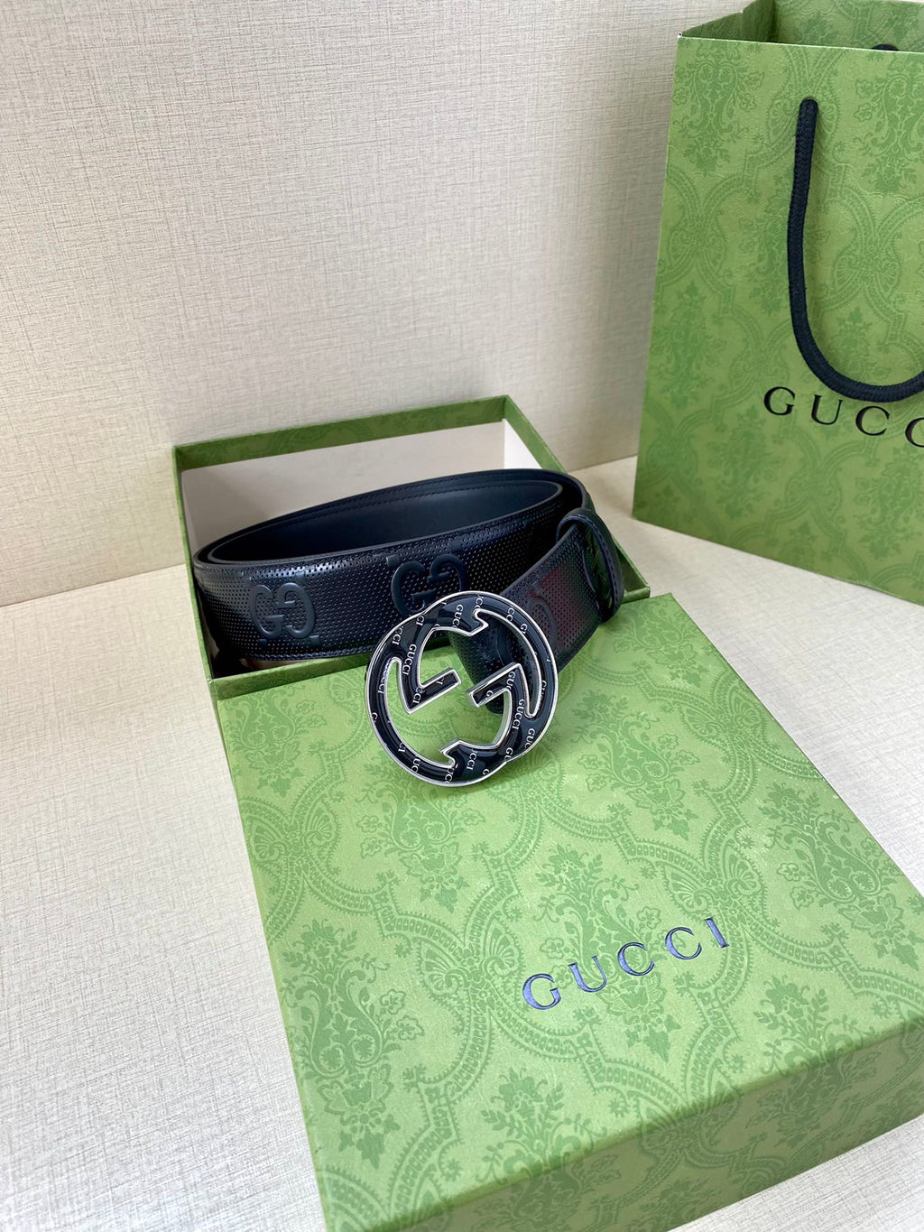 Gucci dark navy leather belt laid in box with oval GG buckle