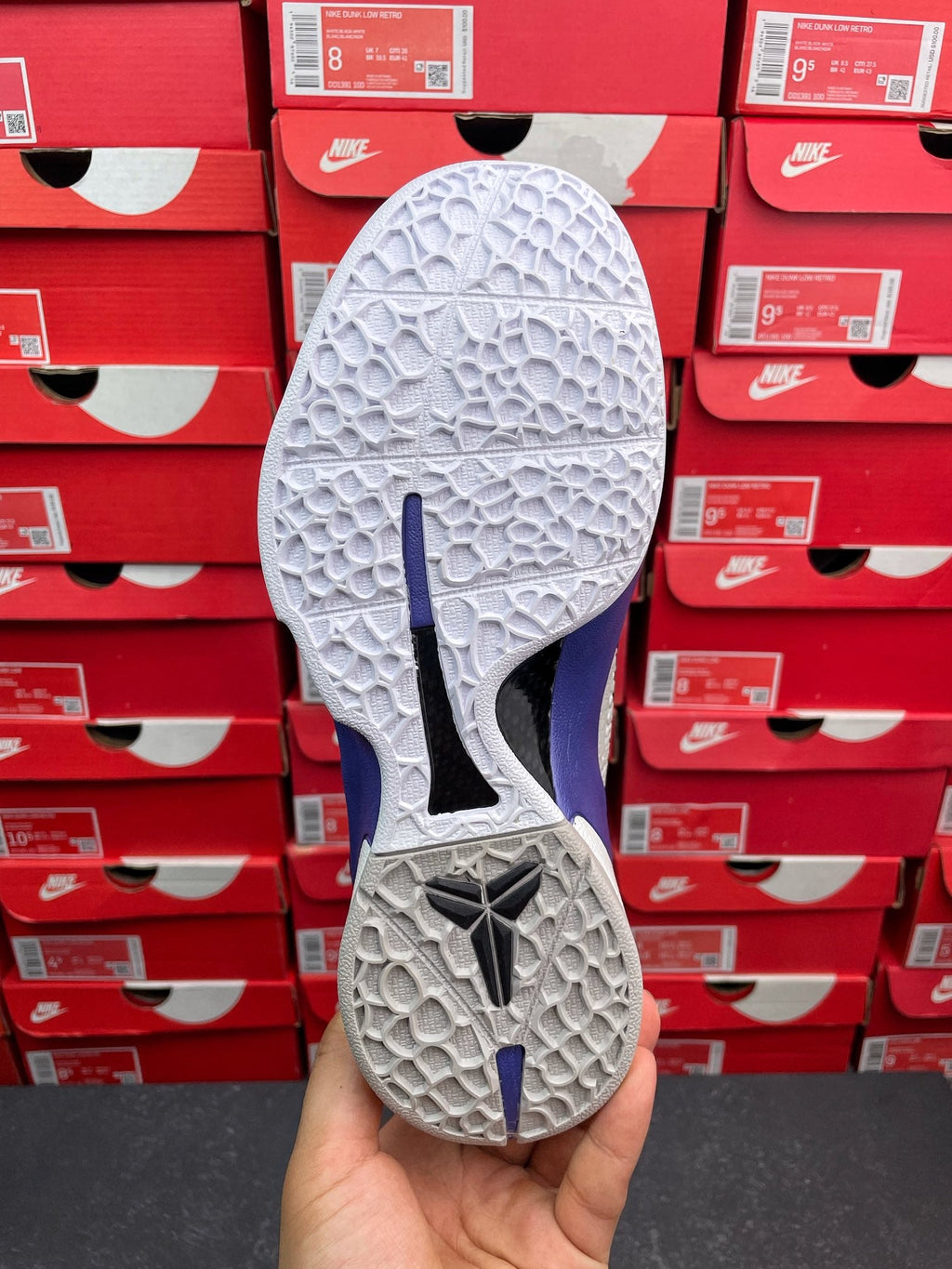 White basketball sneaker outsole with blue traction marks and textured tread.