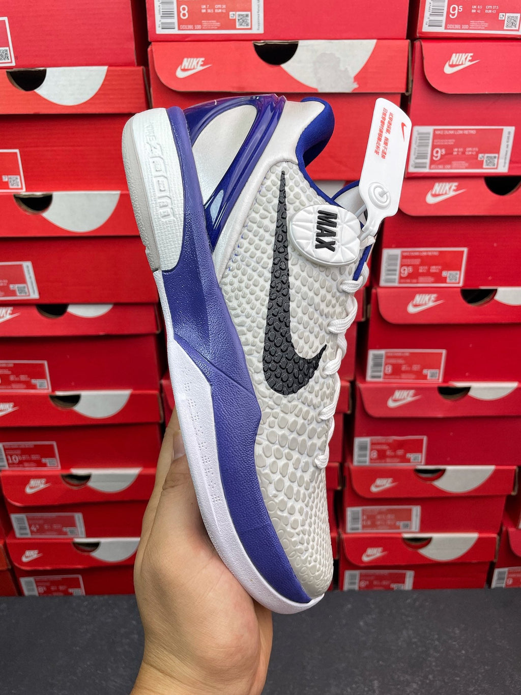 White and blue basketball sneaker, side view with blue sole and laces.