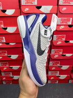 White and blue basketball sneaker, side view with blue sole and laces.