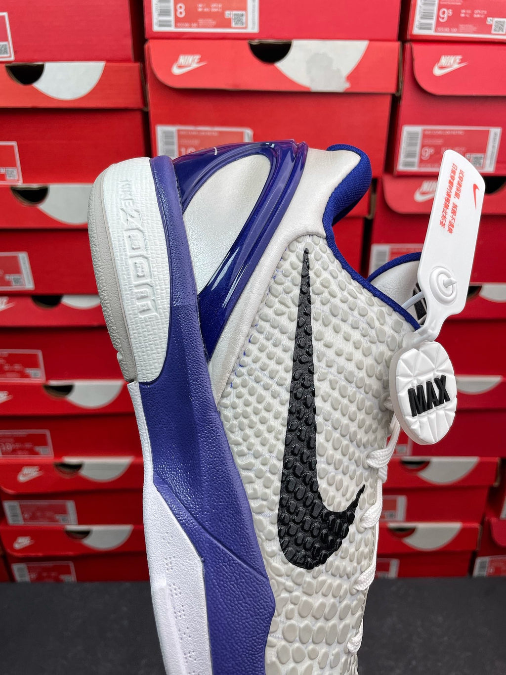 White and blue basketball sneaker, angled side view with black stripe detail.