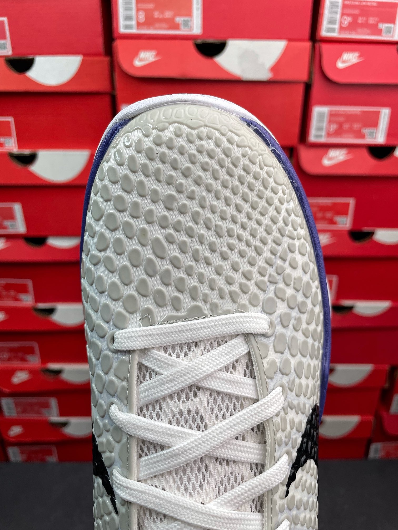 White basketball sneaker toe and upper sole edge with tread pattern.