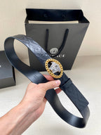 Black belt with embossed pattern and gold Medusa oval buckle