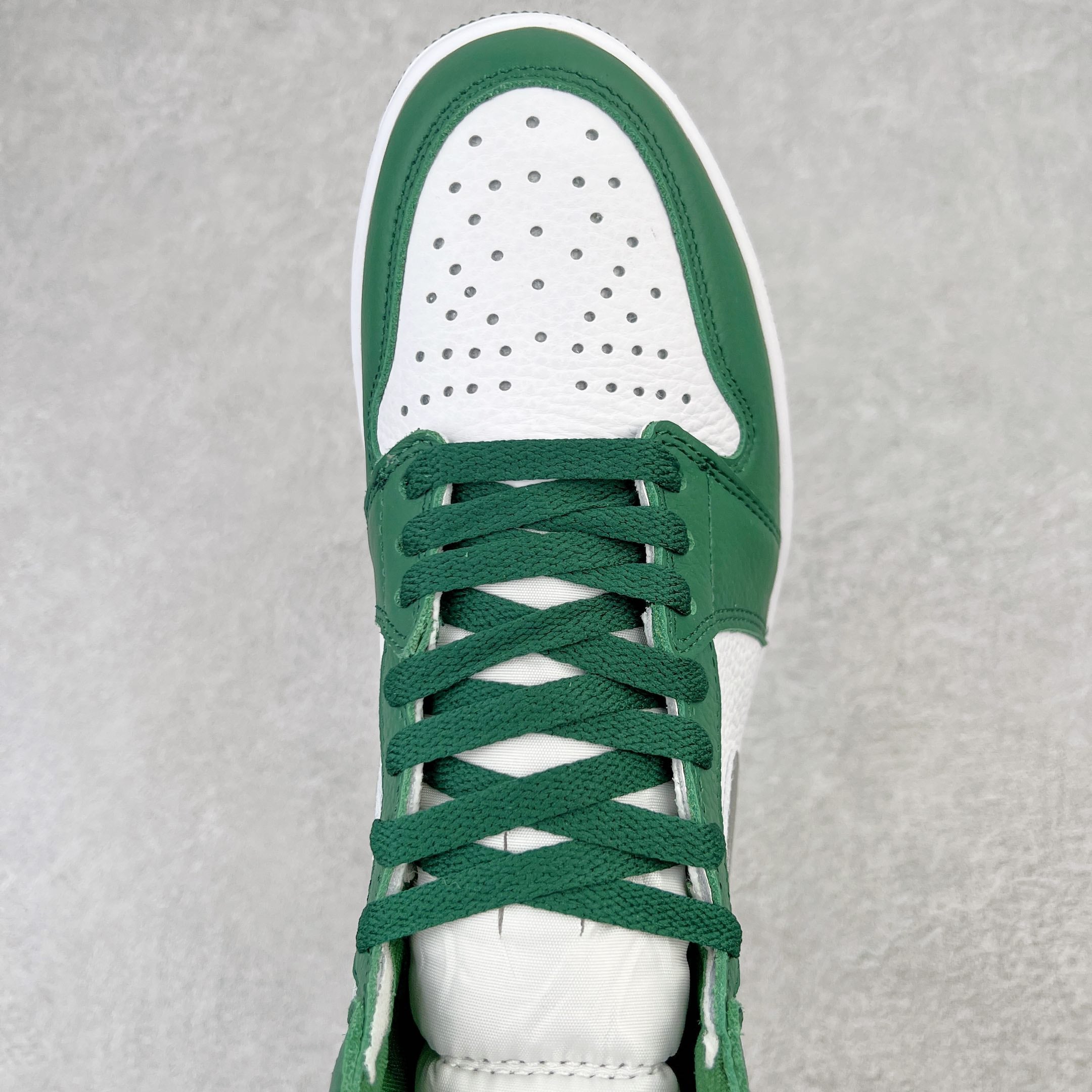Green and white high-top sneaker with perforated toe and green lace-up front