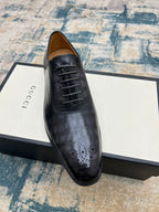 Black leather lace-up dress shoe with perforated toe and stitched seams