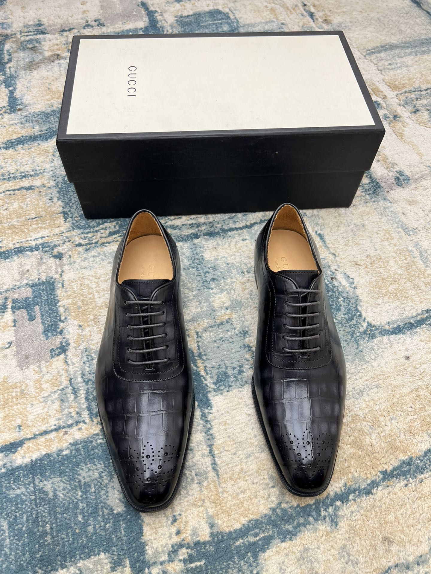 Pair of black leather lace-up dress shoes with perforated toe