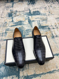 Black leather lace-up dress shoes with brogue-style perforations
