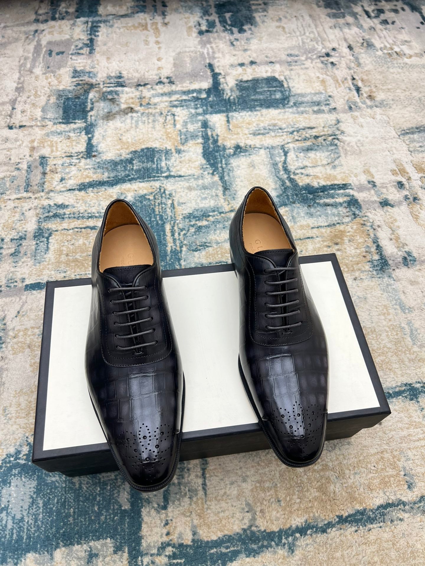 Black leather lace-up dress shoes with brogue-style perforations