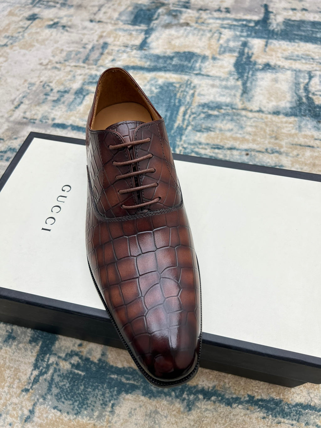 Gucci unisex leather lace-up dress shoe, dark brown textured upper, angled view