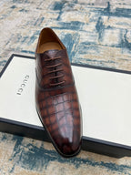 Gucci unisex leather lace-up dress shoe, dark brown textured upper, angled view