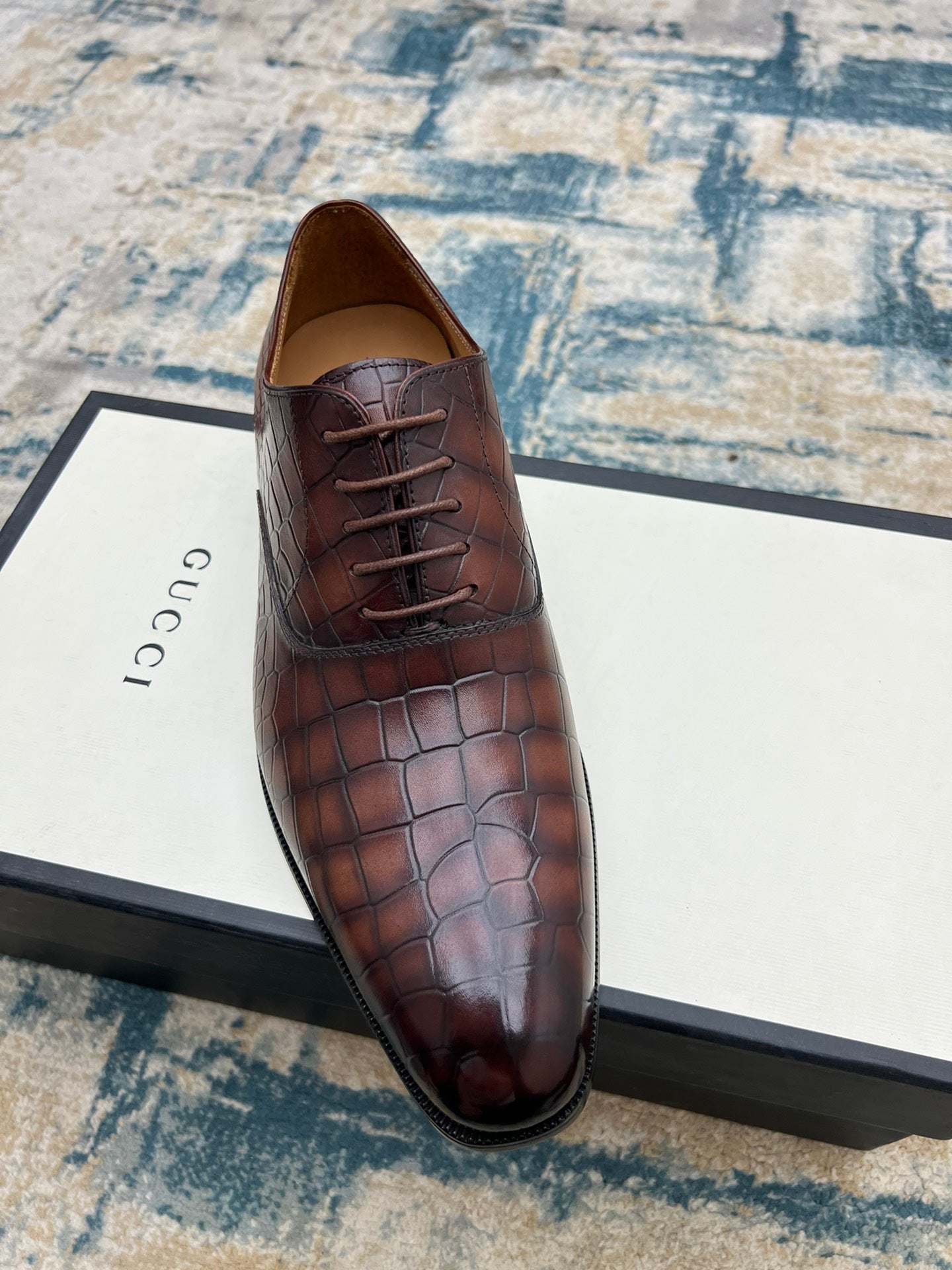 Gucci unisex leather lace-up dress shoe, dark brown textured upper, angled view