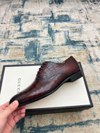 Lace-up dress shoe, burgundy croc-textured leather upper, black sole.