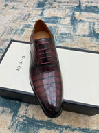 Lace-up dress shoe, burgundy croc-textured leather, front view with laces.