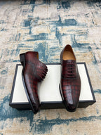 Gucci unisex lace-up dress shoes, burgundy croc-textured leather, side view.