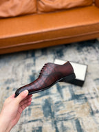 Lace-up dress shoe, burgundy croc-textured leather, side angle on box.