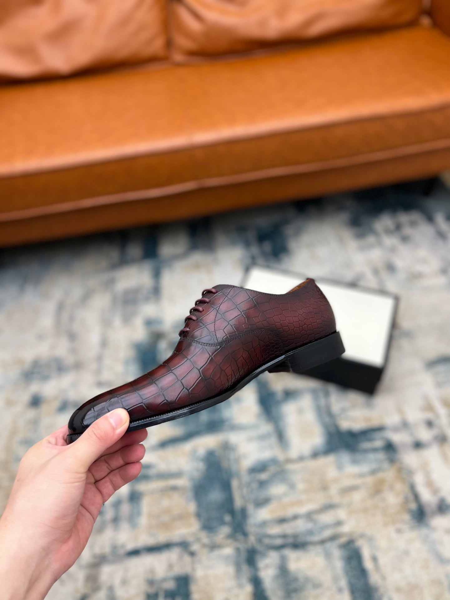 Lace-up dress shoe, burgundy croc-textured leather, side angle on box.