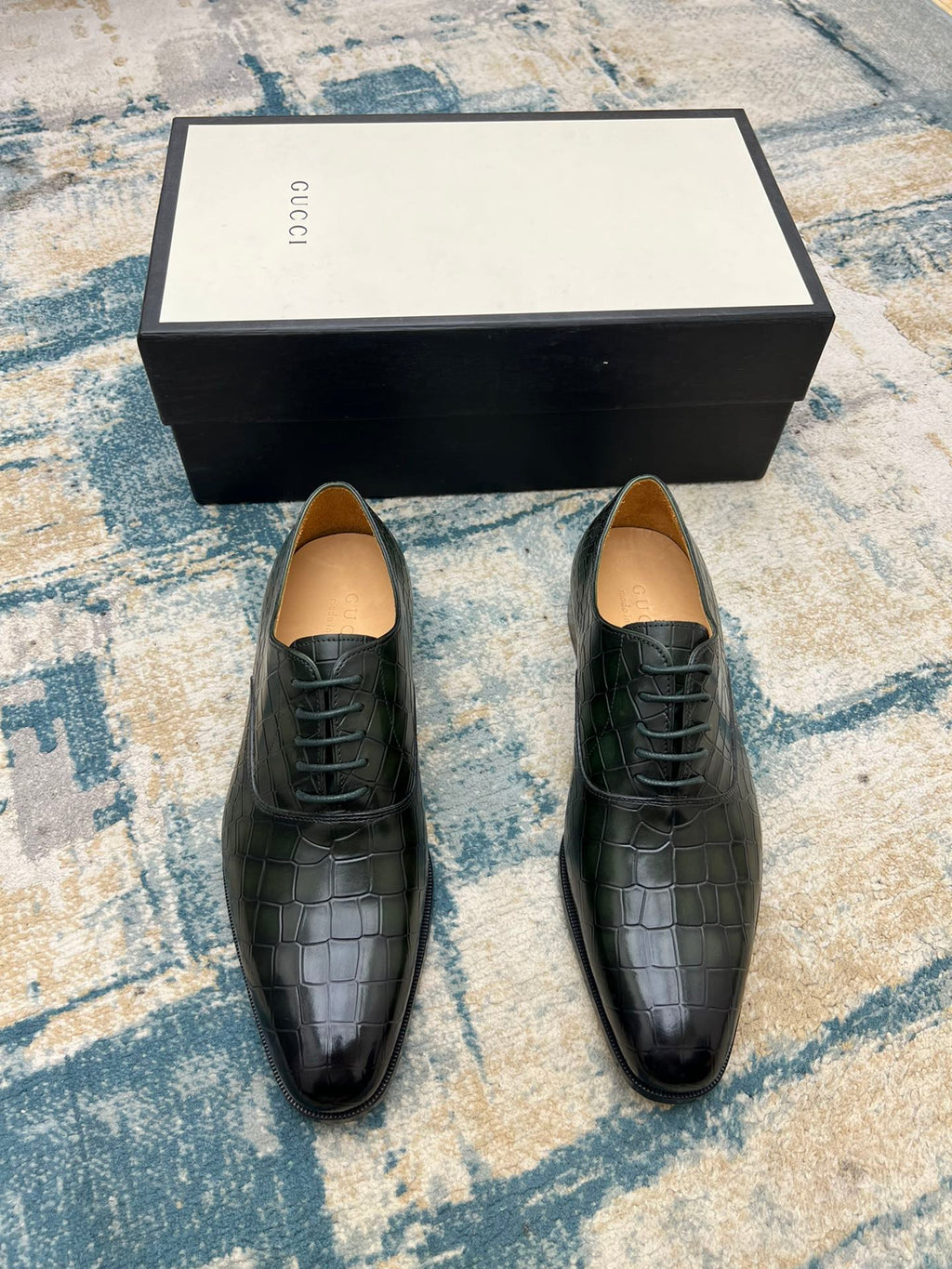 Black crocodile-embossed lace-up dress shoes with tan insoles, front view