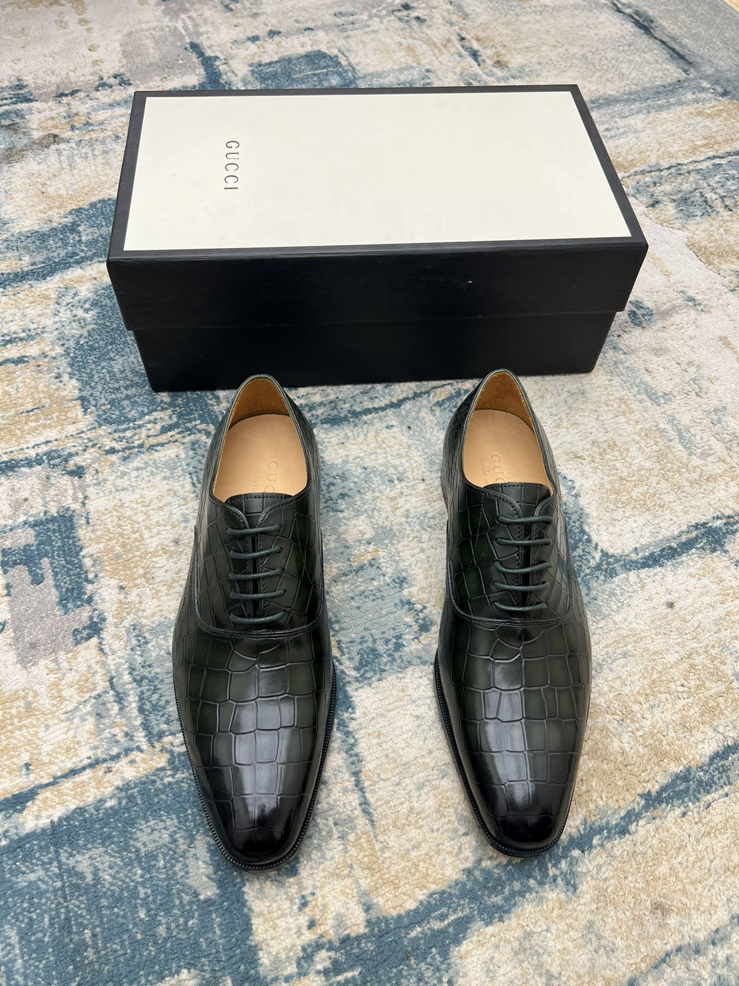 Black crocodile-embossed lace-up dress shoes with tan insoles, front view