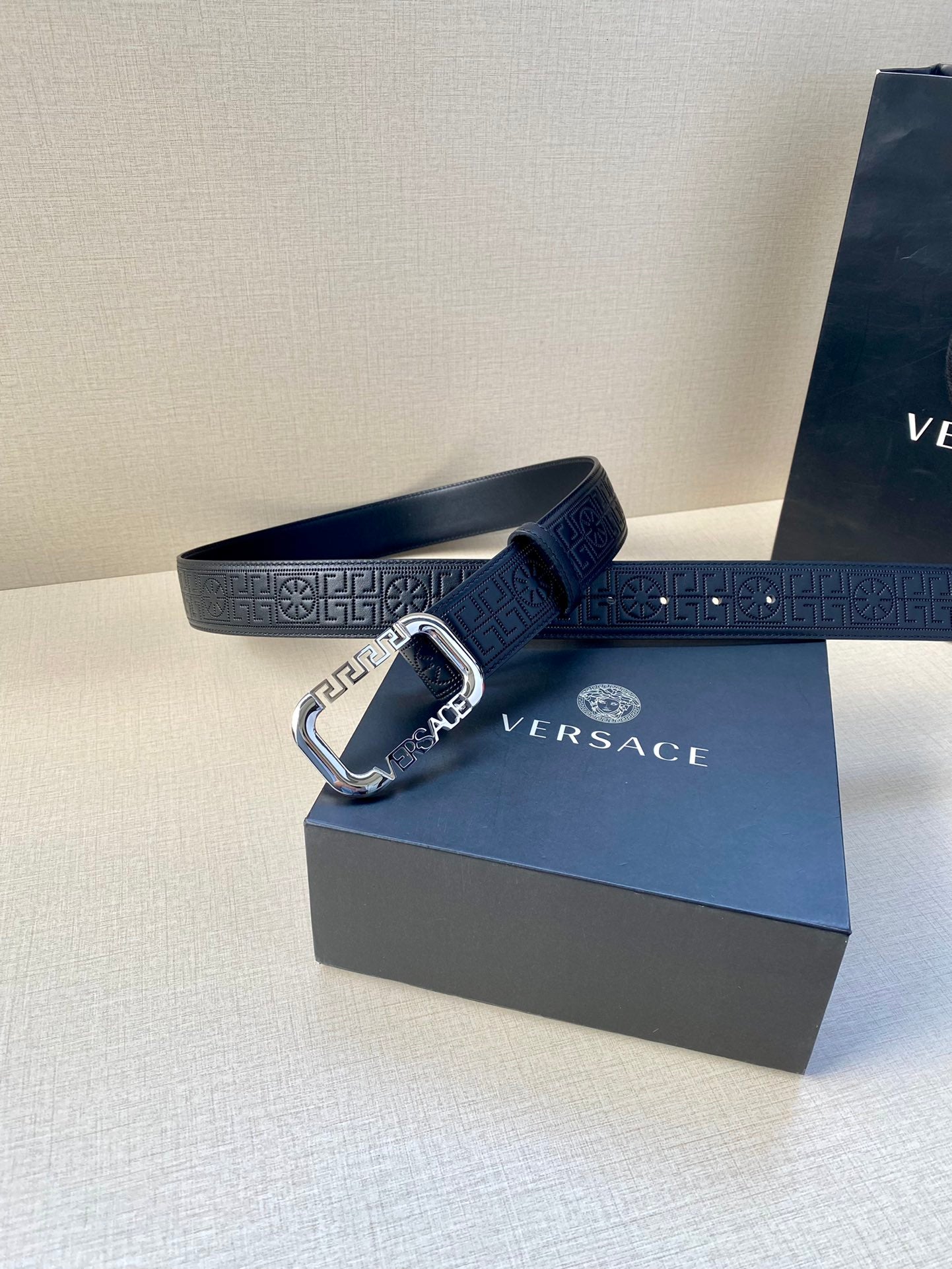 Navy leather belt with embossed Greca strap and silver-tone buckle.