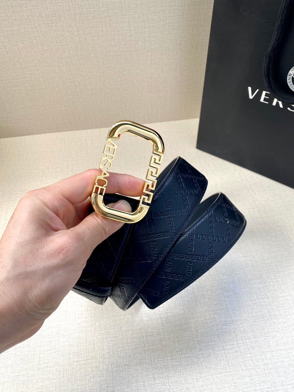 Versace belt strap with dark blue monogram pattern and gold-toned rectangular buckle
