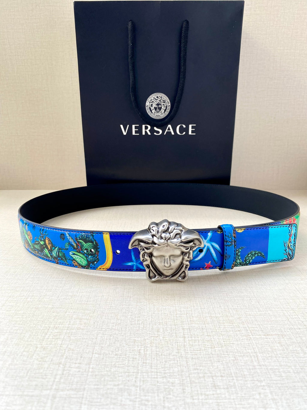 Versace belt: blue graphic strap with star accents and silver-tone buckle