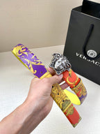 Versace belt in hand with silver Medusa buckle and purple yellow red print strap