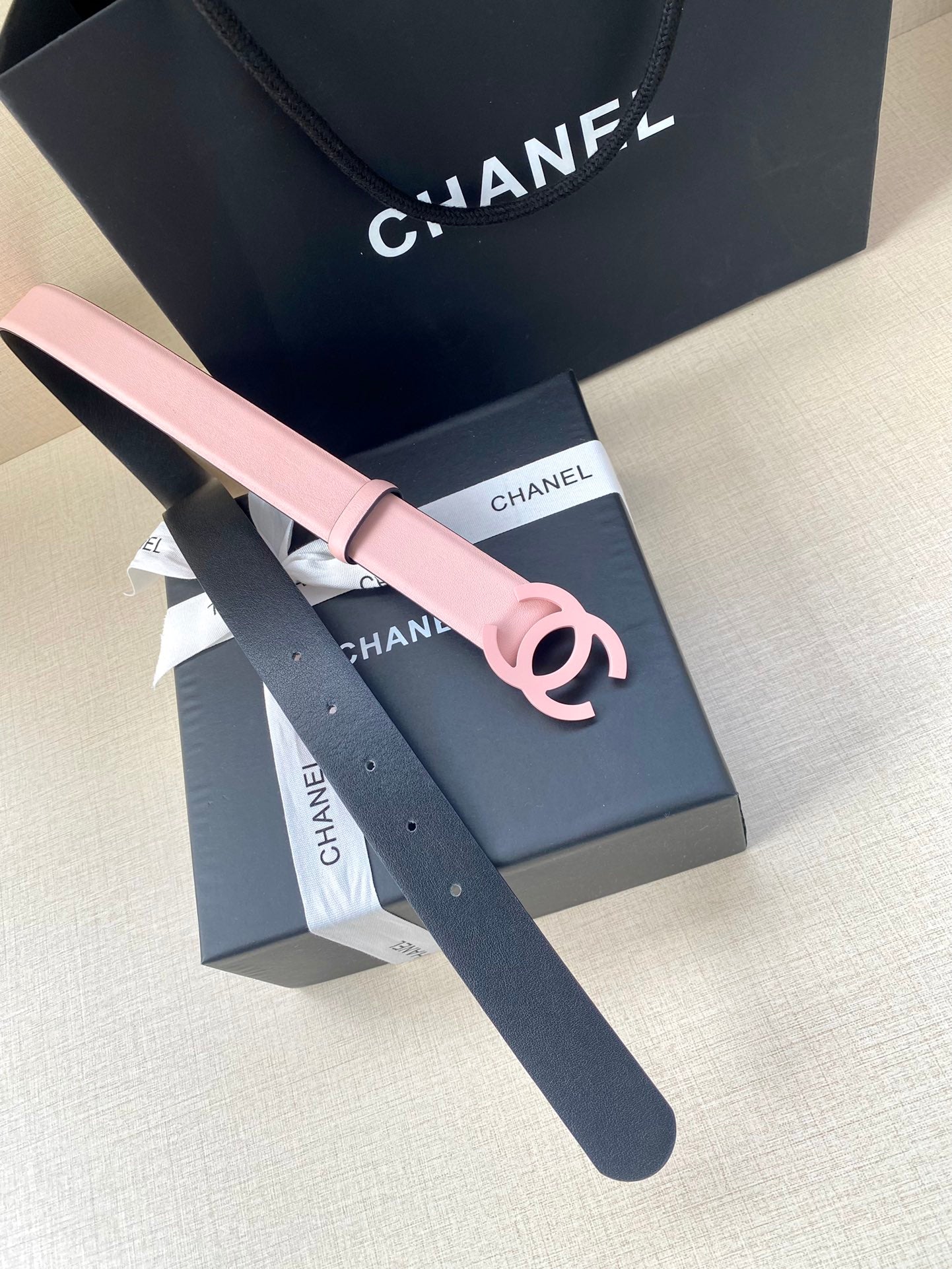 Pink leather Chanel belt with CC logo buckle and belt strap end visible