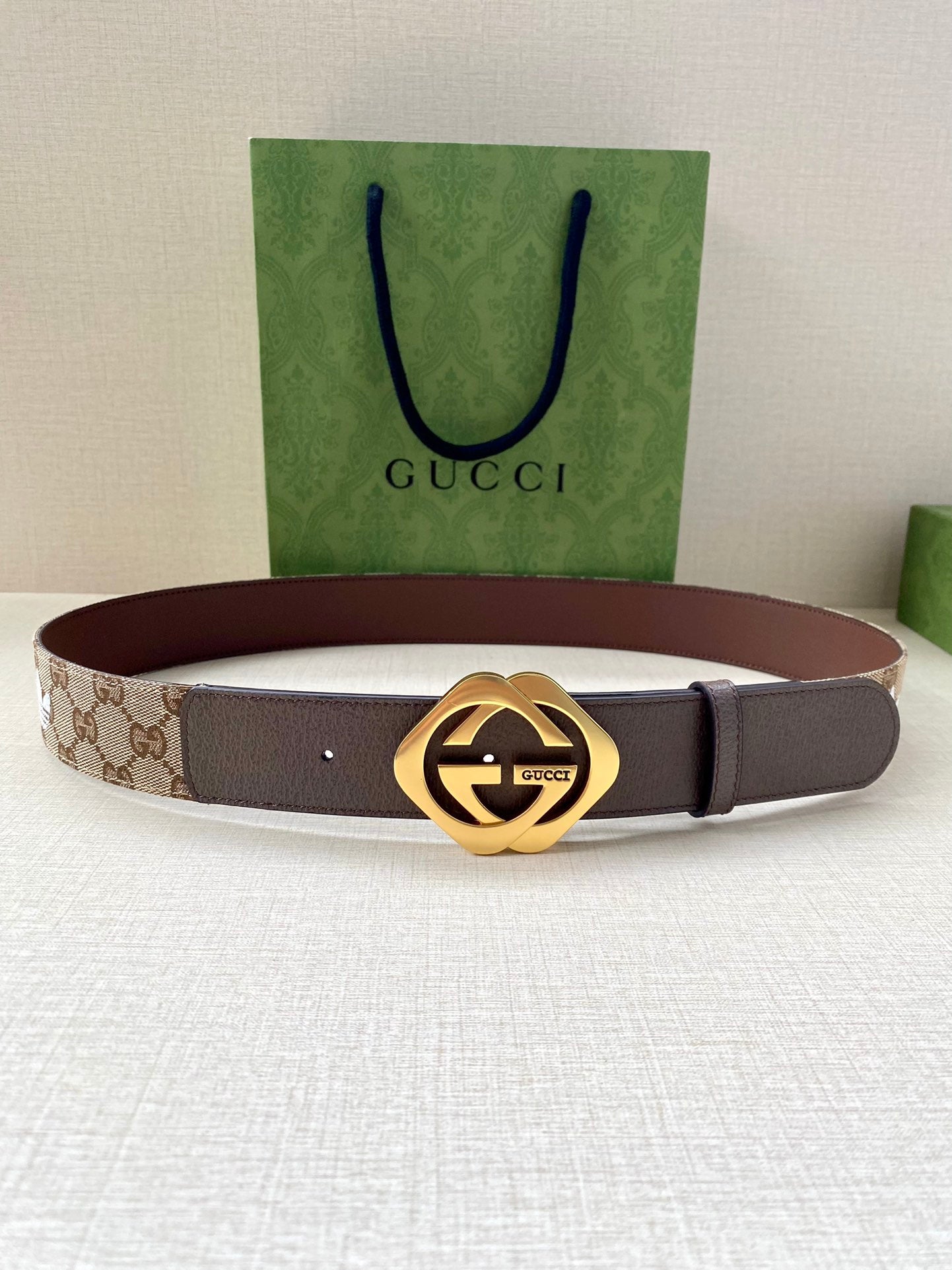 Gucci belt with dark brown strap, small eyelets, and gold-tone circular buckle
