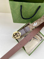 Gucci belt with beige monogram lining, dark leather strap, and gold-tone double G buckle