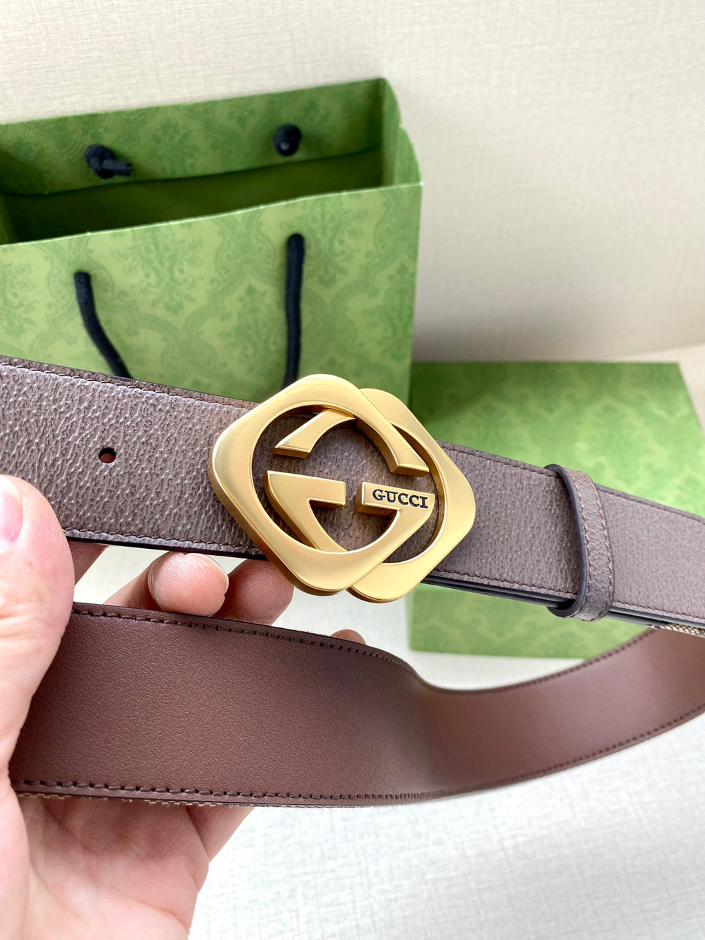 Gucci belt close-up with textured strap and gold-tone double G buckle